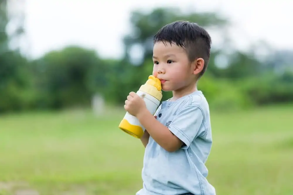 Japanese boy drinking water outside