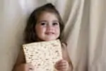 Jewish girl eating a matzo in passover Hebrew holiday