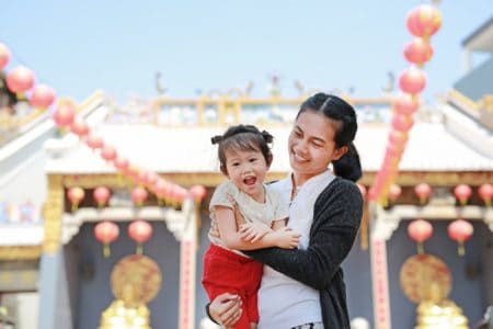 hinese girl and mother having fun in front of China Town Temple