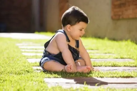 Latin baby boy sitting on grass outdoor