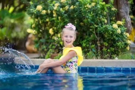 Australian girl playing and spraying water in swimming pool