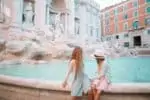 Roman sisters sitting in front of Fountain of Trevi in Rome