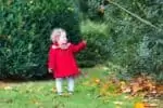 Swedish adorable little girl wearing a red coat in the park