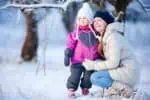 Finnish little girl and mother enjoying beautiful winter day outdoors