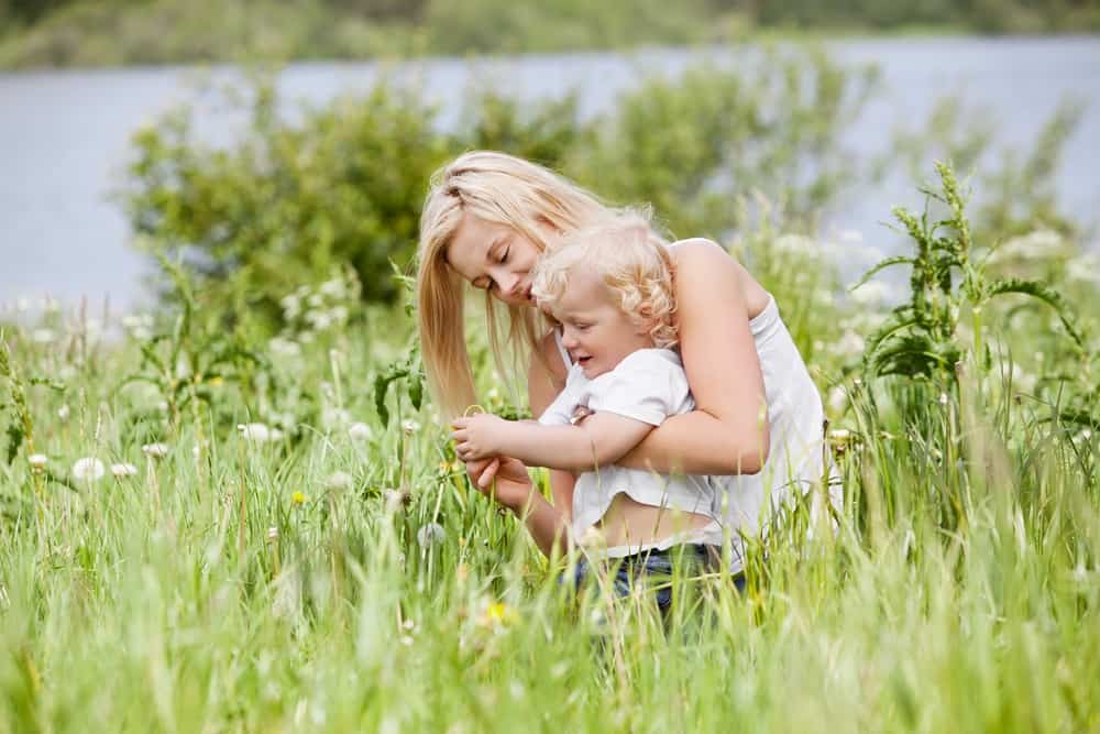 Norwegian boy kid and mother spending time in grass