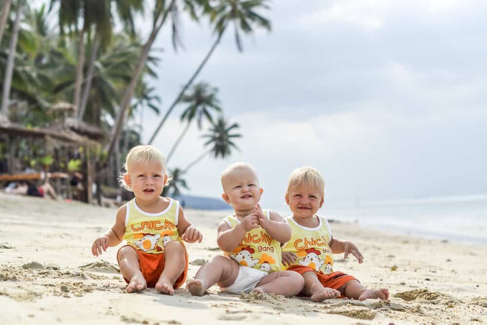 Cuban adorable babies sitting on a tropical beach