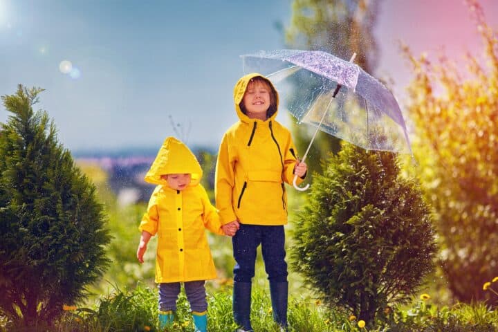 Brothers having fun under the spring sunny rain