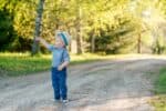 Adorable little boy wearing straw hat pointing something at the park