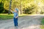 Adorable little boy wearing straw hat pointing something at the park