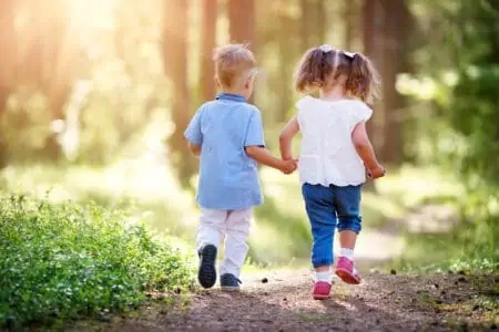 Boy and girl walking in the forest in summer