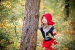 Mysterious little girl wearing red riding hood costume at the park
