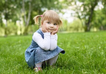 Cute adorable girl sitting in the park