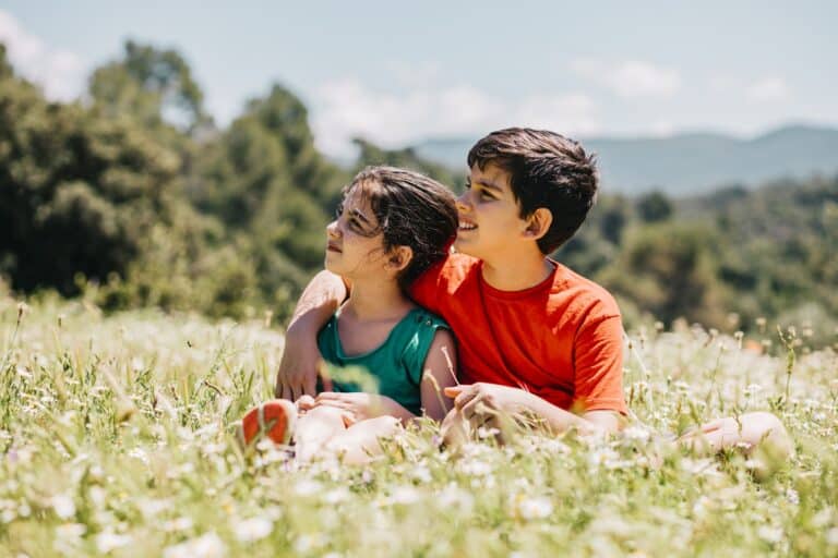 Spanish kids sitting on flowery meadow