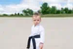 Portrait of little boy wearing karate uniform outdoors