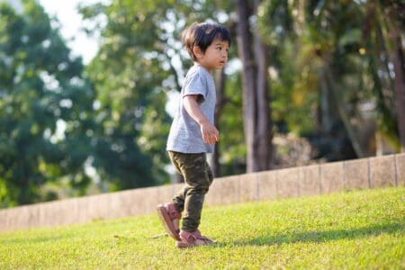 Vietnamese little boy playing outdoor on sunny day
