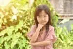 Vietnamese little girl playing in the park on summer day