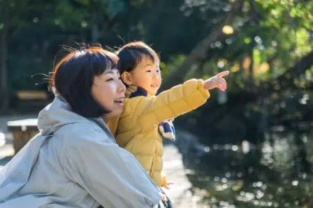 Japanese little girl with her mother having fun at the fun