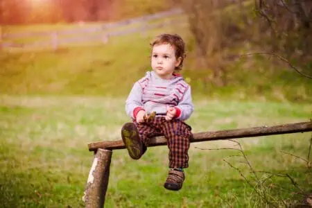 Little boy sitting on a bench in the park