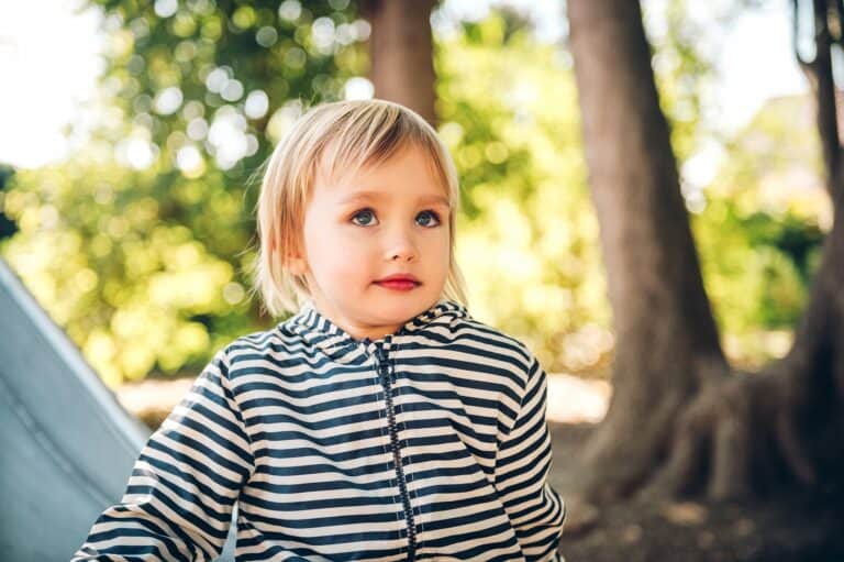 Happy toddler girl playing on playground