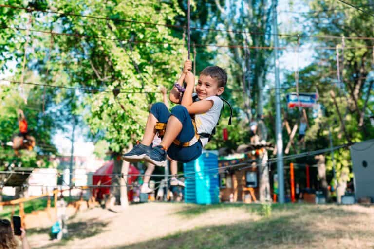 Happy boy enjoying activity in climbing adventure park