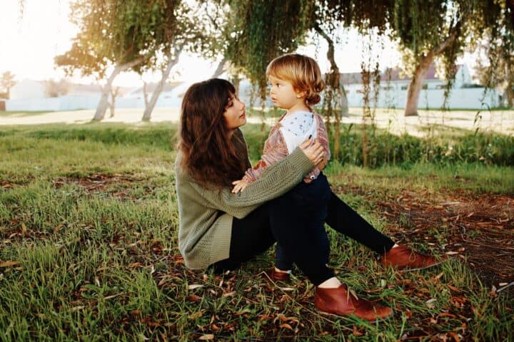 Mother spending time with her son sitting on the grass at the park