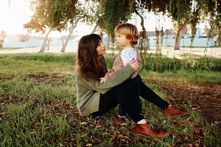 Mother spending time with her son sitting on the grass at the park